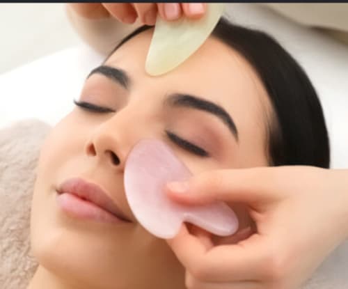 Spa facial treatment with pink gua sha stone at Le Mas des Poules wellness center, Saint-Roman-de-Malegarde
