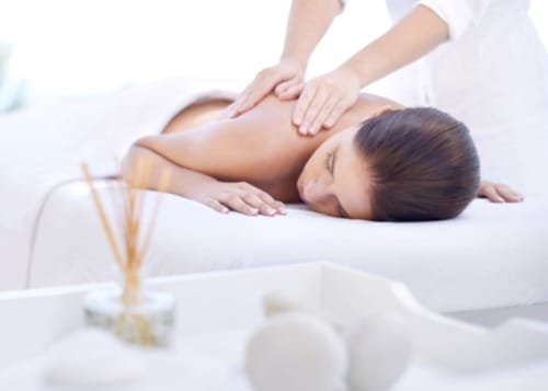 Woman enjoying back massage at Le Mas des Poules spa in Saint-Roman-de-Malegarde