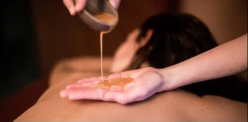 Massage oil dripping onto hands at Le Mas des Poules spa in Saint-Roman-de-Malegarde, France