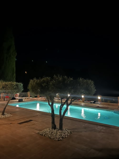 Piscine illuminée la nuit avec olivier, transats et terrasse au Mas Aurel de Provence, Peypin