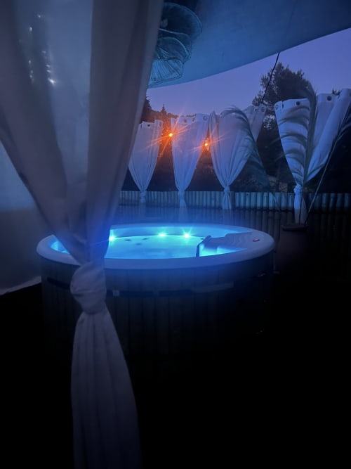 Bain à remous illuminé au crépuscule avec bungalows drapés et lanternes au Mas Aurel de Provence, Peypin