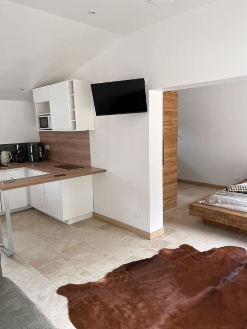 Cuisine ouverte et séjour contemporains au Mas Aurel de Provence avec finitions bois et écran mural