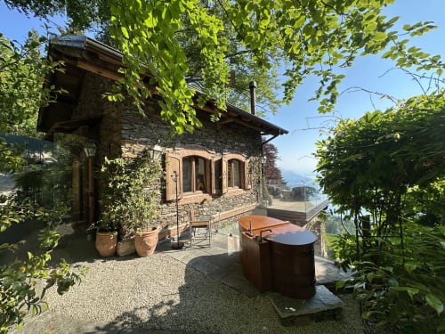 Cottage in pietra di lusso con vista panoramica sul lago, vasca idromassaggio esterna e vegetazione lussureggiante a Stresa, Lago Maggiore