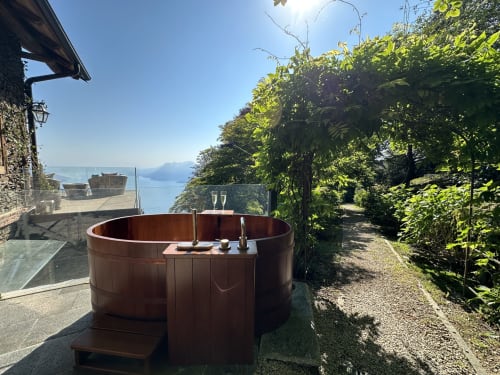 Wooden hot tub on terrace overlooking Lake Maggiore at luxury spa retreat in Stresa, Italy