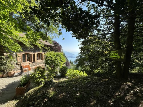 Lussuoso chalet immerso nella rigogliosa foresta con vista sul Lago Maggiore, insegna Forest Gym visibile, rifugio a Stresa Italia