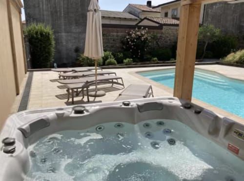 Vasca idromassaggio con vista sulla piscina a Casa Mia Vacanza B&B, circondata da lettini e cortile recintato