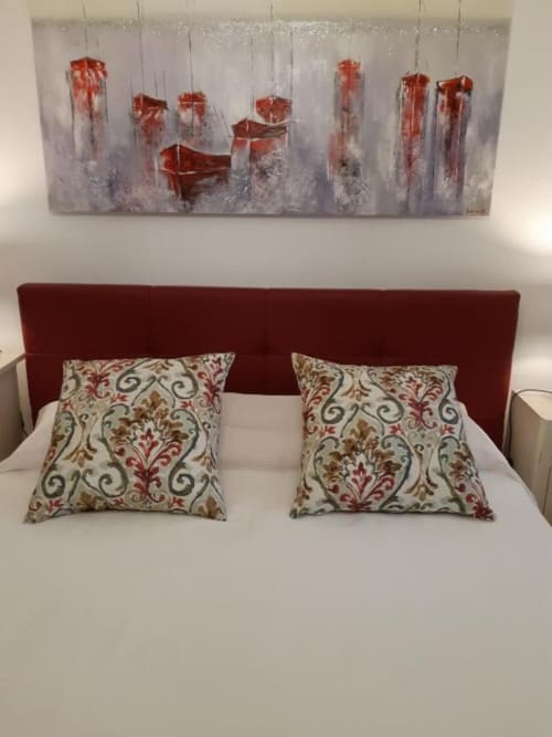 Camera Deluxe Bordeaux Triple a Casa Mia Vacanza con testata bordeaux, cuscini decorativi e quadro con barca rossa sopra il letto.