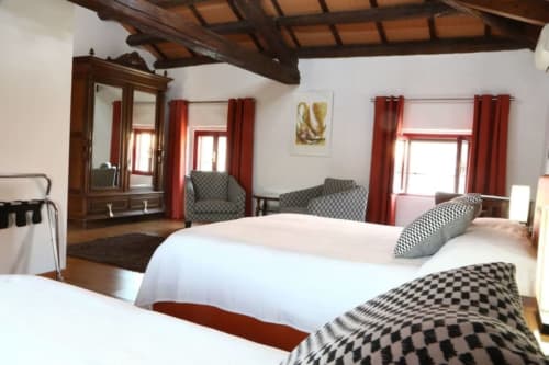 Camera tripla lusso Loft Arancione a Casa Mia Vacanza con travi in legno, letti bianchi e tende rosse