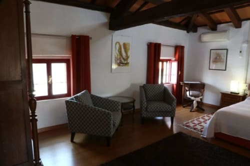 Lussuosa camera tripla Loft Arancione in Casa Mia Vacanza con poltrone decorate, travi in legno e dettagli rossi