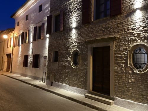 Affascinante edificio storico in pietra, Casa Mia Vacanza B&B in Italia, con facciata illuminata e finestre ad arco nella notte