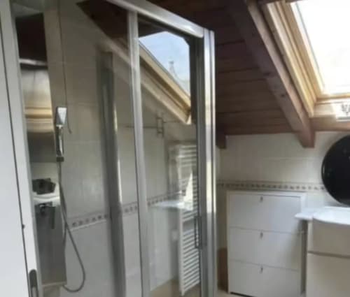Bagno moderno nella Tramonto Deluxe Room di Casa Mia Vacanza con doccia, vasca bianca e lucernario