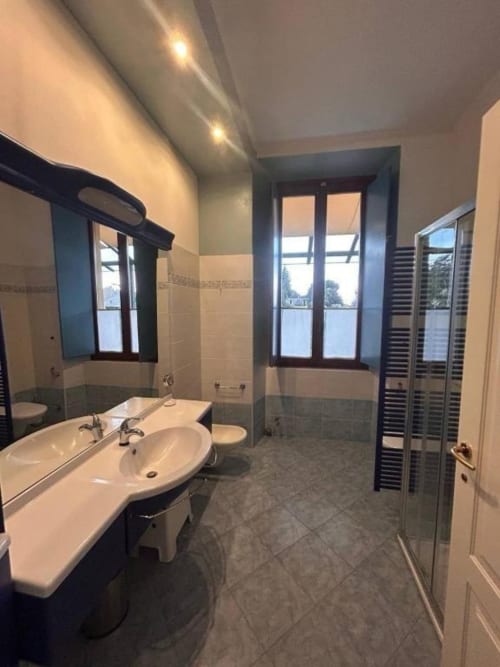 Lussuoso bagno di Mia Experience a Monza, con doppio lavabo, doccia in vetro e ampie finestre