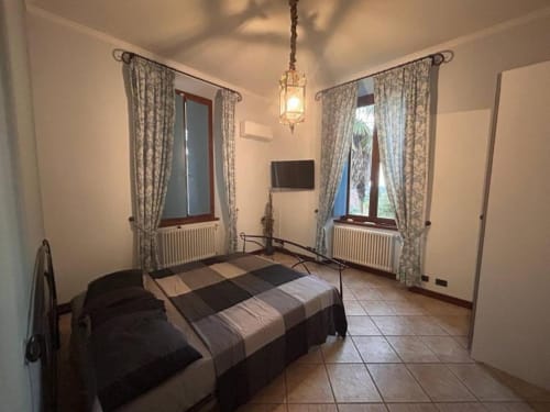 Camera Quadrupla Stella Luxury presso Mia Experience a Monza con letto a righe, due finestre e illuminazione a sospensione