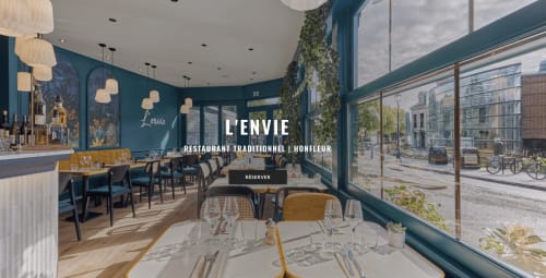 L'Envie restaurant in Honfleur with teal walls, elegant dining setup, and street views
