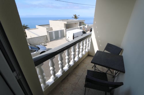 Balcón orientado al Atlántico con asientos con vistas a la costa de Funchal desde la villa SpecialStays