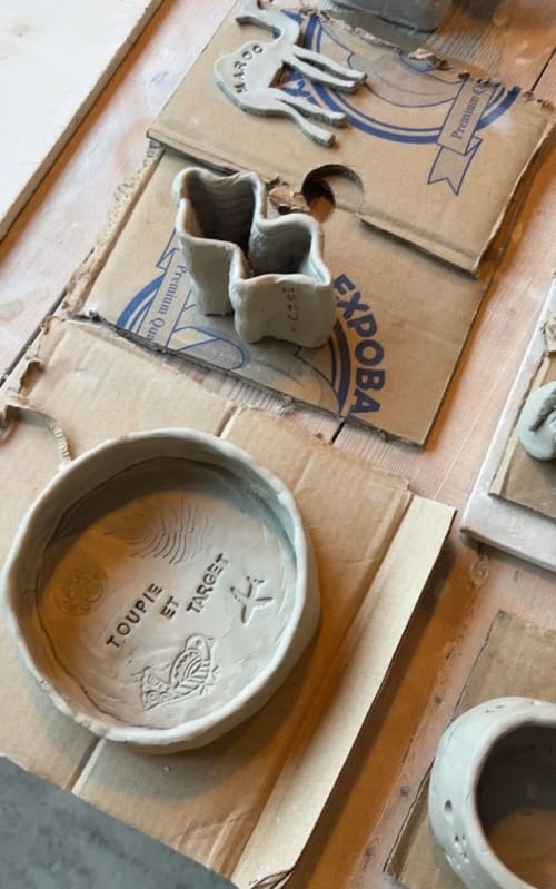 Pièces de poterie en argile séchant sur du carton au Riad Eucalyptus, hôtel ethnique à El Ghazouane, Maroc