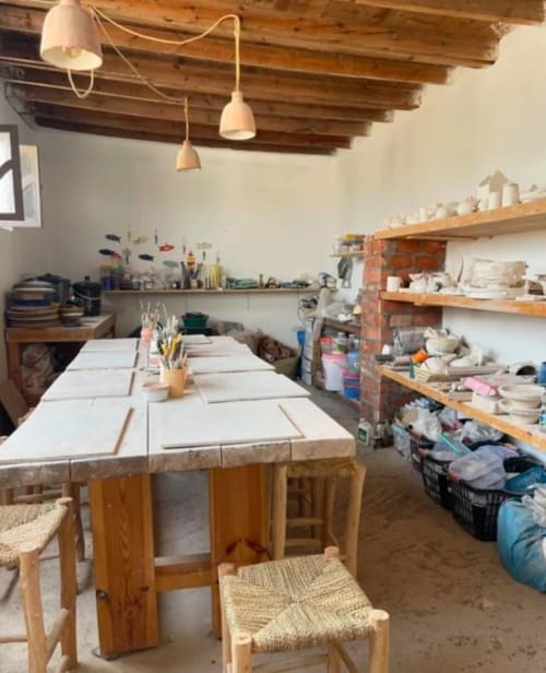 Atelier de poterie au Riad Eucalyptus, hôtel ethnique à El Ghazouane, avec tables de travail et fournitures artisanales