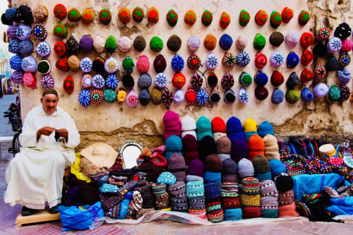 Artisan marocain présentant ses poteries colorées et ses créations tissées au Riad Eucalyptus à El Ghazouane