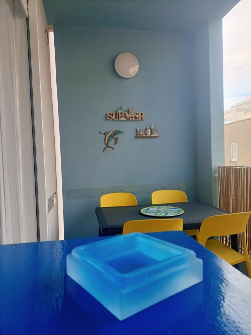 Zona pranzo Blue Dwelling di Le Case di Esteca con sedie gialle, arredamento costiero e vista sul balcone a Gallipoli