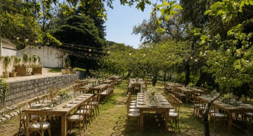 Espaço de refeições ao ar livre da Quinta do Carril com mesas de madeira entre árvores em Portugal