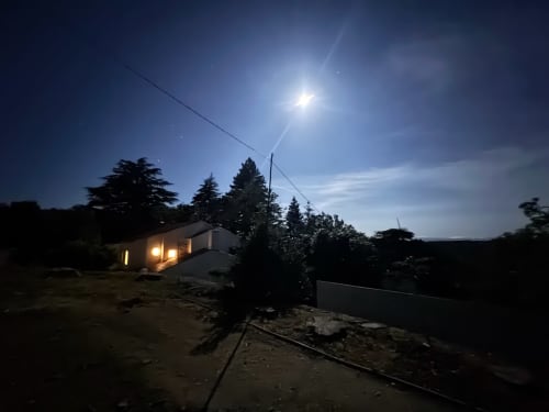 Quinta do Carril brilhando ao entardecer sob luz da lua, cercada por pinheiros em Portugal