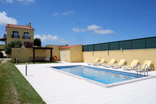 Be SilverCoast villa in Serra D'El Rei with private pool, yellow loungers, and yellow-walled accommodation building under