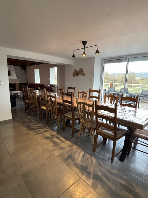 Spacieuse salle à manger avec tables et chaises en bois, vue sur les montagnes au Mas De Bannayoux, Couteuges