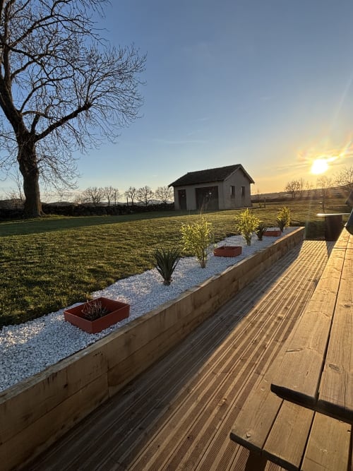 Terrasse en bois dominant les jardins paysagers du Mas de Bannayoux, Couteuges, avec vue sur la campagne
