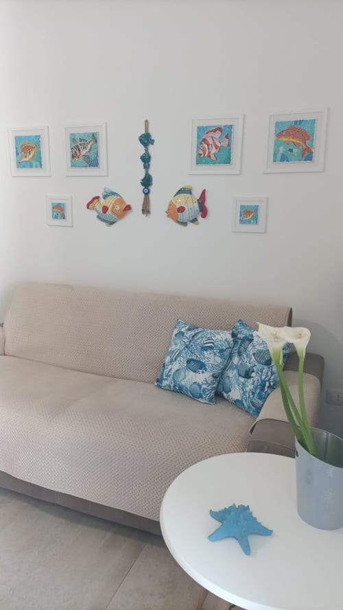 Appartamento Blue Dwelling a Le Case di Esteca con decorazioni a tema marino e pesci sopra il divano beige