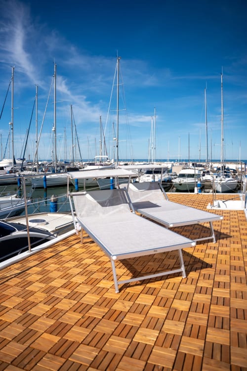 Marina soleggiata con lettini bianchi vista vela presso BHE House Boat Experience a Cesena