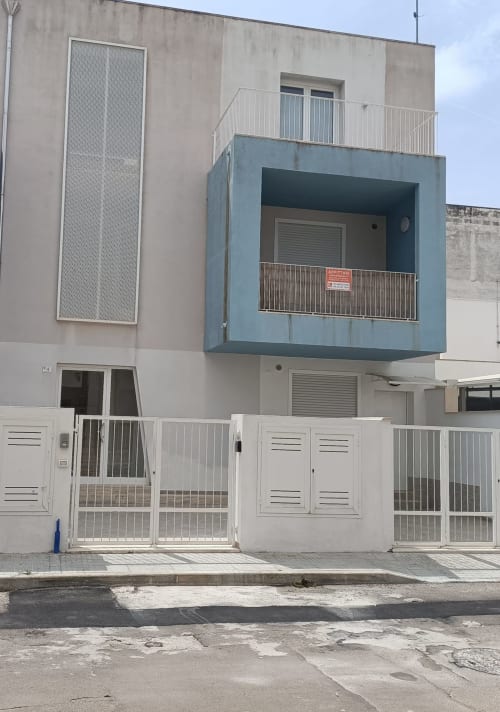 Esterno appartamento Blue Dwelling presso Le Case di Esteca BnB a Gallipoli con cancelli metallici bianchi e balconi