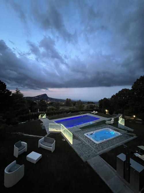 Dämmerungsblick auf den Pool und Whirlpool Il Sentiero dei Goti mit toskanischer Landschaft und Gewitterhimmel