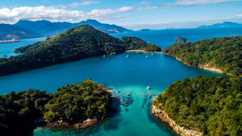 Baía turquesa tropical cercada por ilhas e florestas exuberantes, perfeita para aventuras de praia no Rio de Janeiro