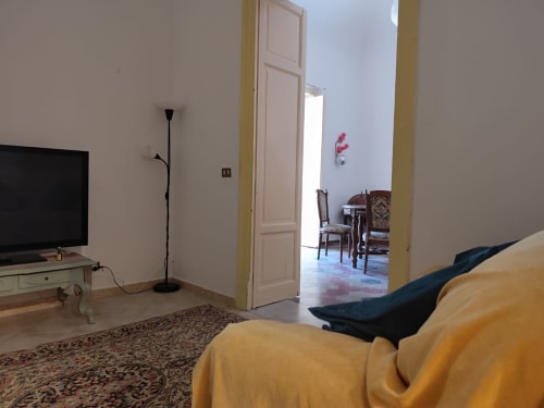 Camera da letto Mappamondi B&B Venezia con divano giallo, TV e vista sulla zona soggiorno