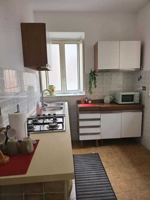 Cucina compatta nella Stanza Blu di Mappamondi B&B Venezia con fornello a gas, lavello, armadi e microonde