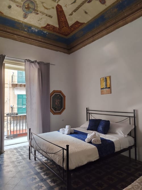 Camera Blu di Mappamondi B&B a Venezia con soffitto ornato, letto in ferro e vista sul balcone della città