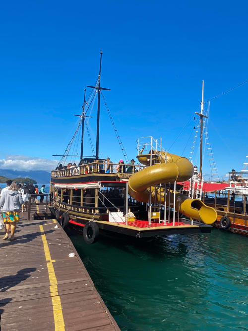 Barco turístico colorido com escorregadores aquáticos amarelos atracado no cais do Rio de Janeiro em um lindo dia ensolarado