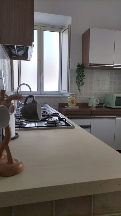 Cucina moderna nella stanza Blu di Mappamondi B&B Venezia, con fornello a gas, mobili chiari e vista sulla finestra