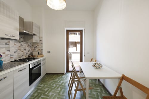 Cucina e zona pranzo moderna nell'appartamento Profumo di Mare a ViOletta, Roma, con vista mare e pavimenti in piastrelle geometriche