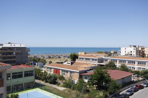 Vista aerea degli appartamenti ViOletta a Roma con vista sul mare, spiaggia e costa mediterranea sullo sfondo