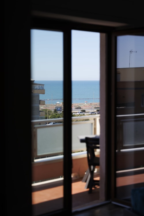 Porte balconate in vetro con vista mare dall'appartamento Profumo di Mare di ViOletta a Roma