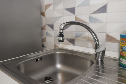Lavello moderno con rubinetto cromato e piastrelle geometriche, appartamento Profumo di Mare a Roma