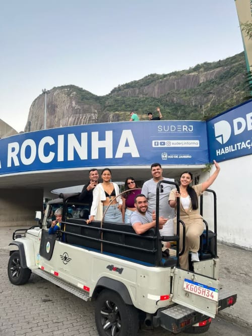Grupo de hóspedes em passeio de jeep aberto na Rio Vibes Hostel, Rio de Janeiro, com formações rochosas montanhosas ao fundo