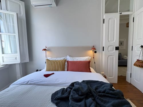 Quarto luminoso em Casa Amanhada, Grândola com roupa de cama branca, almofadas às riscas e candeeiros de cobre para leitura
