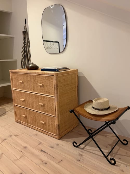Quarto elegante na Casa Fataca, Grândola com cômoda de rattan, espelho oval e detalhes decorativos