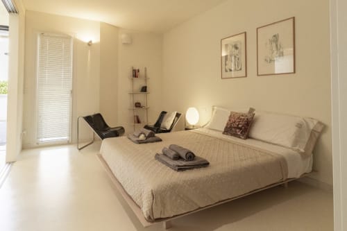 Modern bedroom at Pescara INN Pineta Retreat with cream bedding, work area, garden view, and contemporary furnishings