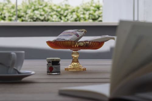 Elegant decorative bird figurine on golden pedestal dish in Pescara INN Pineta Retreat apartment, with garden view and