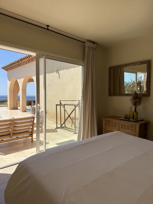 Chambre de luxe à la Villa La Vista Lumio avec vue sur mer, mobilier contemporain et accès à la terrasse