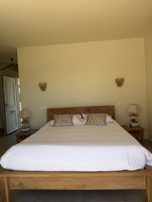Chambre Chantilly à Villa La Vista à Lumio avec lit en bois, linge blanc et vue sur la mer