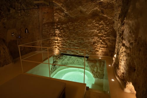 Sala sotterranea con piscina illuminata dell'hotel Mileca Sciù Sciù a Sciacca, Sicilia